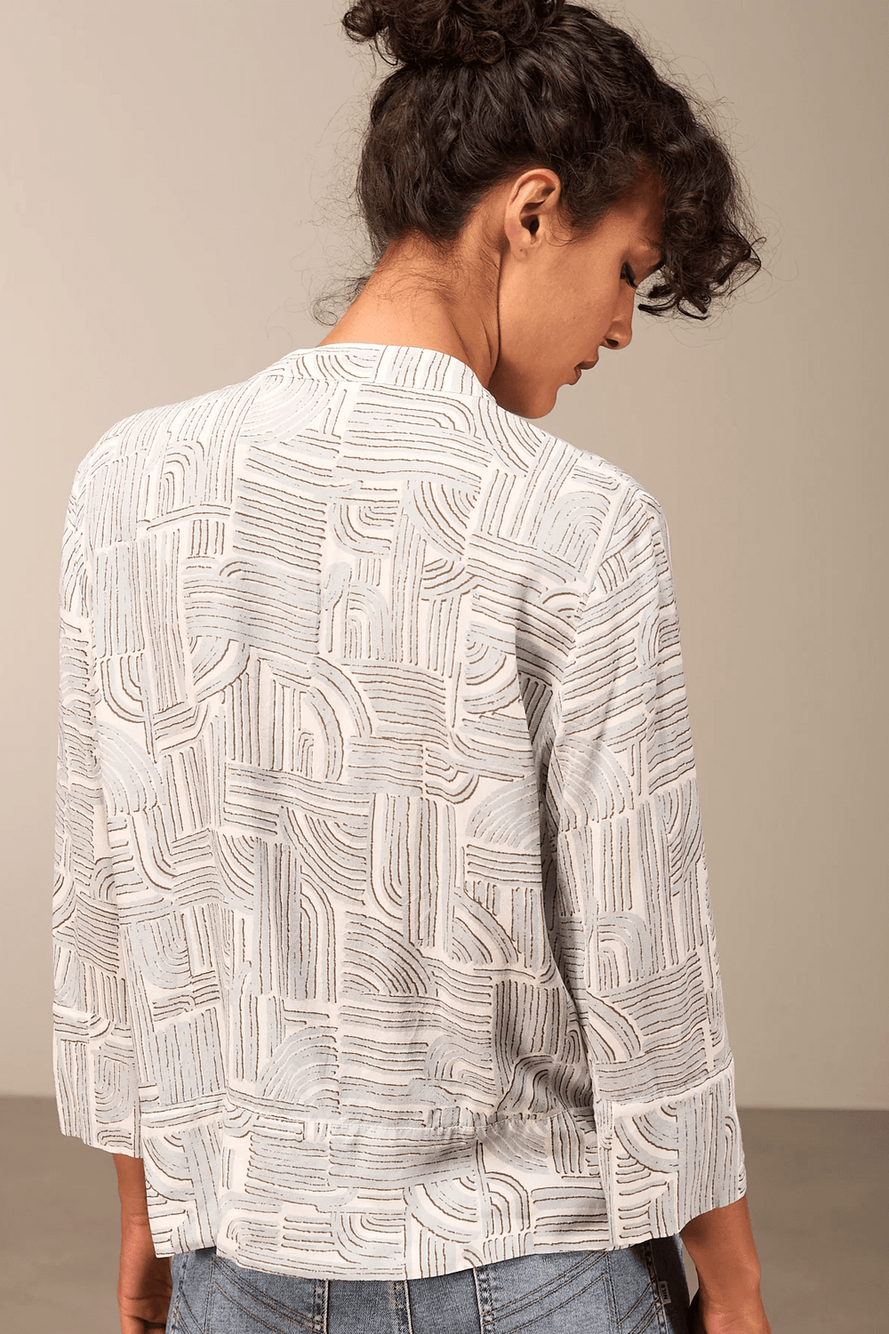 Blouse à manches 3/4 avec motif géométrique, coupe décontractée et col rond, vue de dos. Style moderne et élégant.