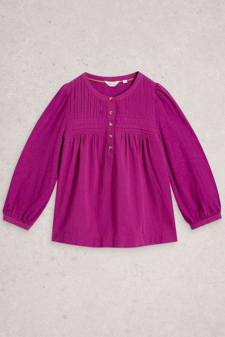 Blouse plumetis à plastron froncé en tissu fluide, couleur vive, manches longues, idéal pour un style féminin et élégant, rentré dans un jean.