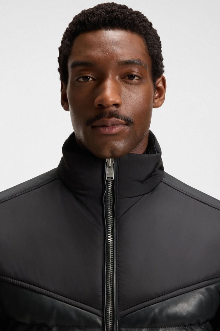 Homme portant un blouson en cuir d’agneau avec col montant et finitions côtelées, style moderne et élégant.