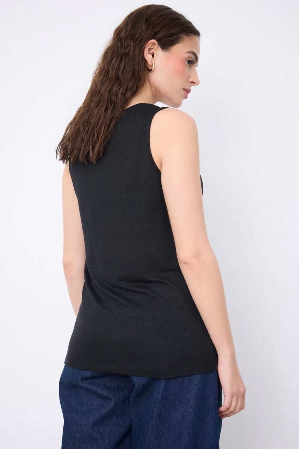 Dos d'une femme portant la Camisole Yana en maille légère, coupe fluide et sans manches, idéale pour l'été.
