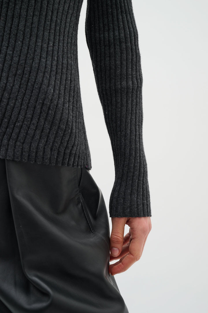 Cardigan Gia à côtes fines en maille côtelée avec encolure en V, présenté avec un pantalon fluide noir pour un look chic.