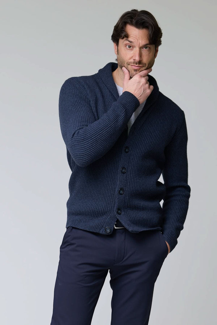 Homme portant un cardigan à col châle en laine, maille épaisse, bleu, avec fermeture à boutons, idéal pour les superpositions élégantes.