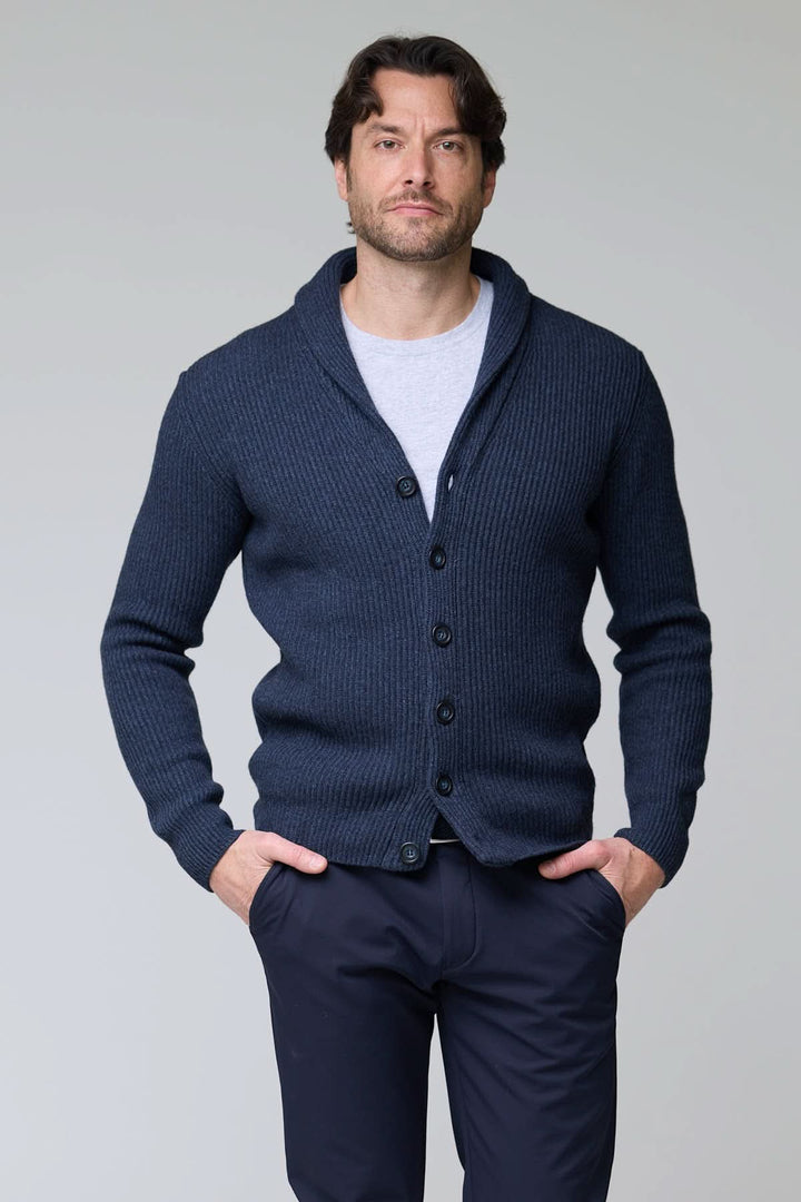 Homme portant un cardigan à col châle en laine bleu avec maille côtelée et fermeture à boutons, ajoutant une touche élégante et confortable.
