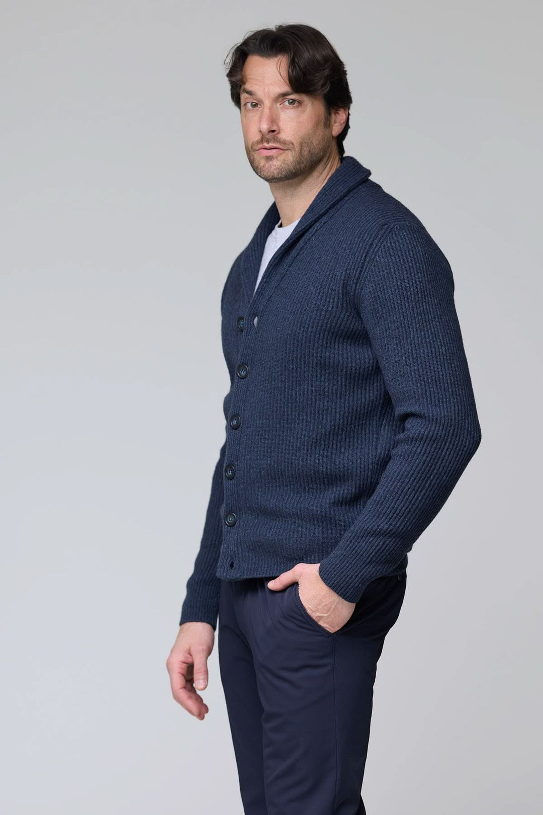 Cardigan à col châle en laine bleu marine avec maille côtelée et boutons sur le devant, porté par un homme.