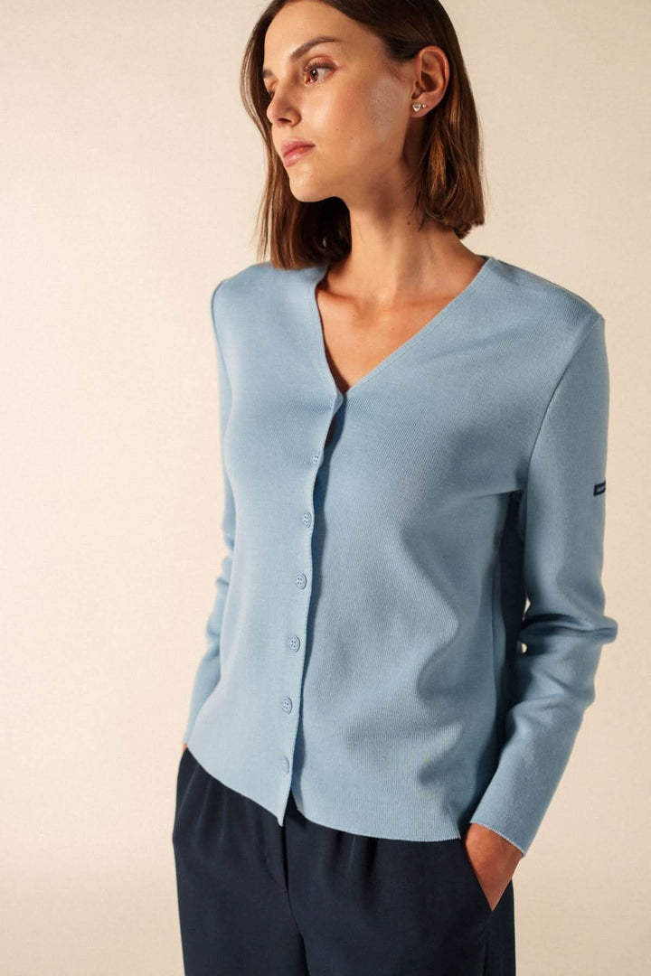 Femme portant un Cardigan de laine BREVANDS bleu avec encolure en V, boutons discrets et manches longues.