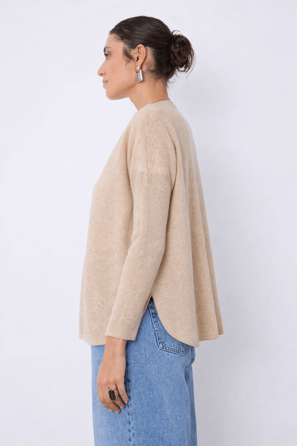 Femme portant un Cardigan en cachemire Alicia beige à manches longues et coupe droite, idéal pour les superpositions quotidiennes.