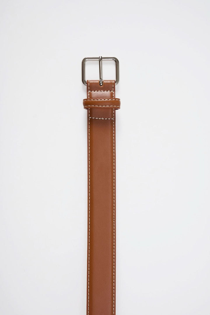 Ceinture en cuir lisse marron avec boucle métallique et surpiqûres contrastantes sur fond blanc.