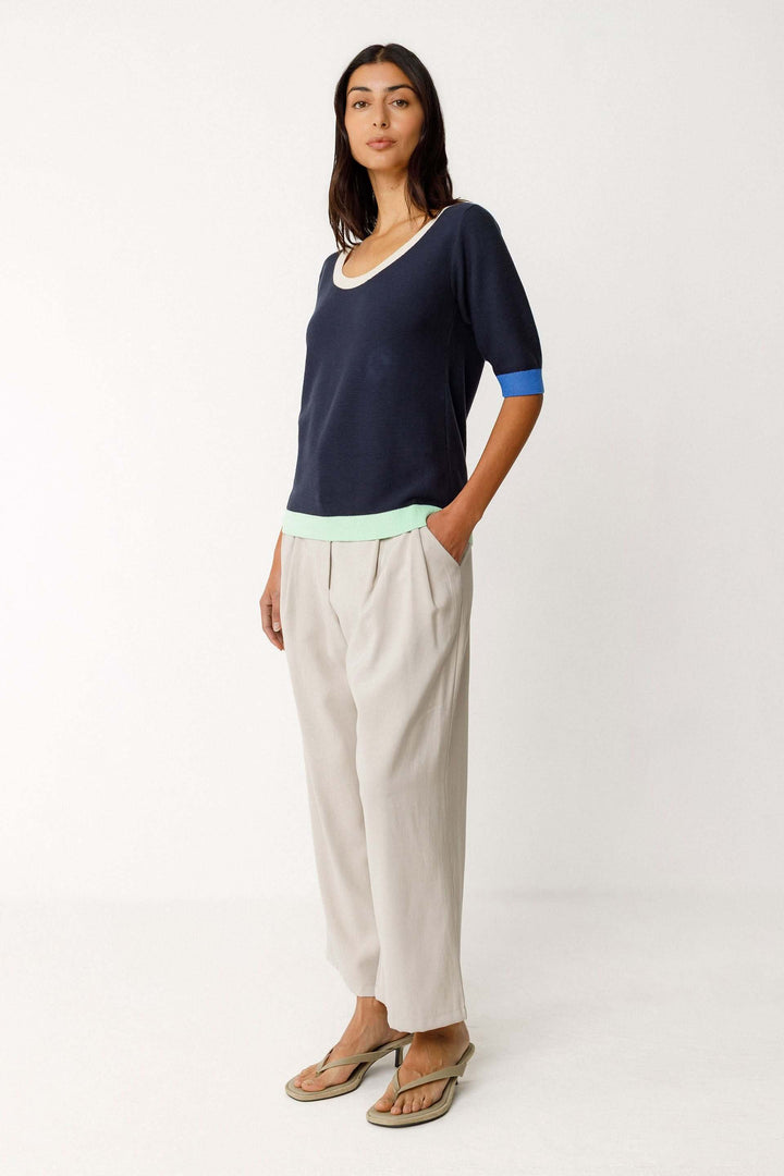Femme portant un Chandail Lary tricot léger col rond manches courtes, confortable et moderne, avec détails contrastants.