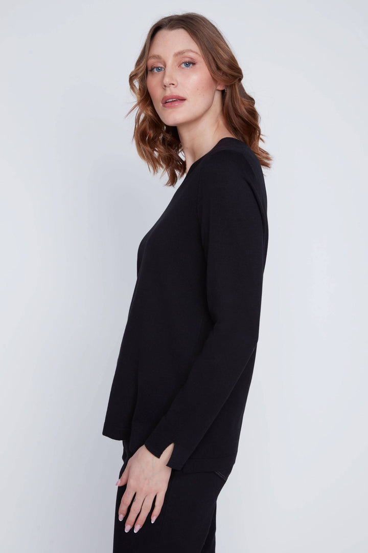 Femme portant un chandail col V noir à manches longues, coupe fluide.