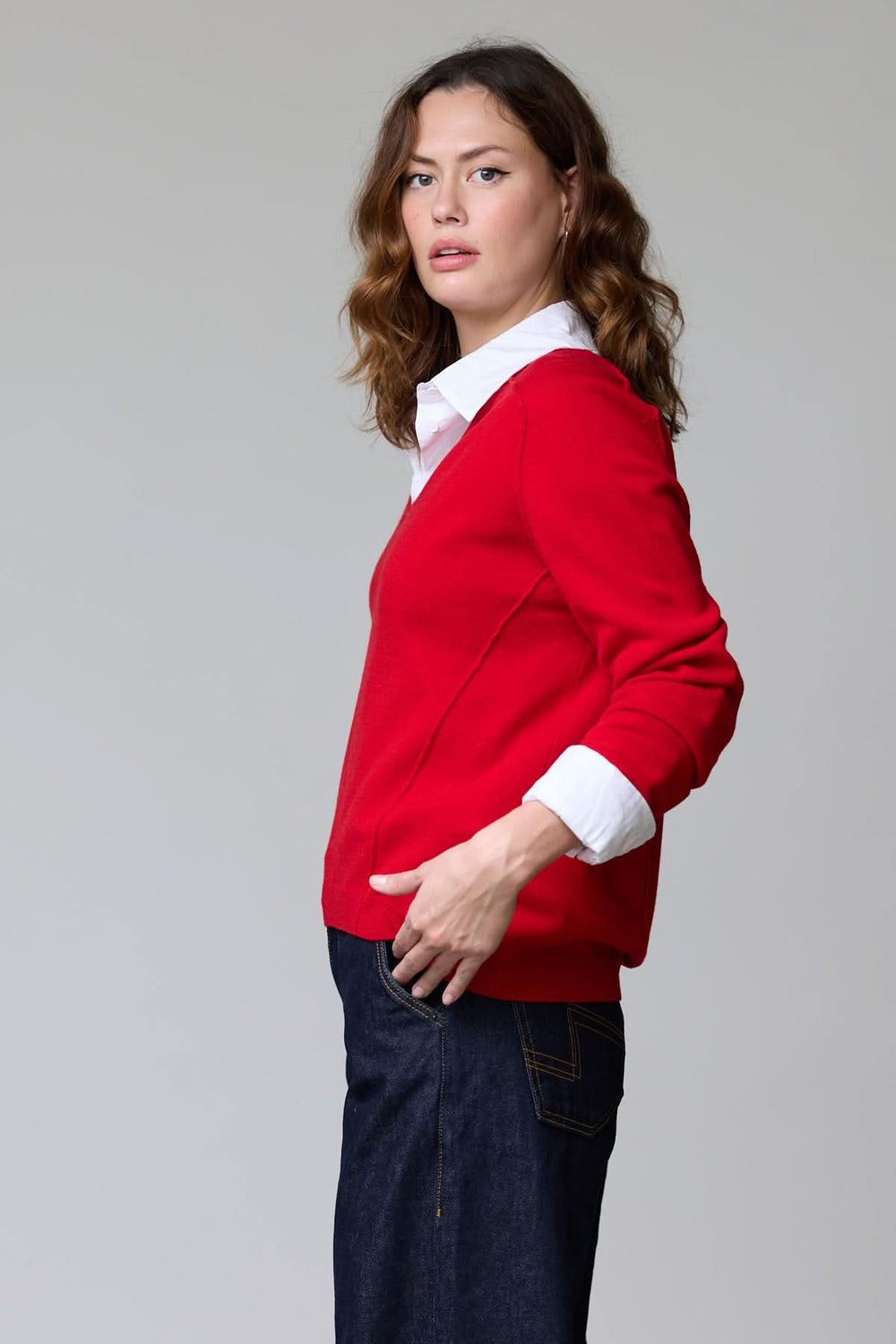 Chandail col en V classique en maille douce, porté par une femme sur une chemise blanche, offrant un look élégant et polyvalent.