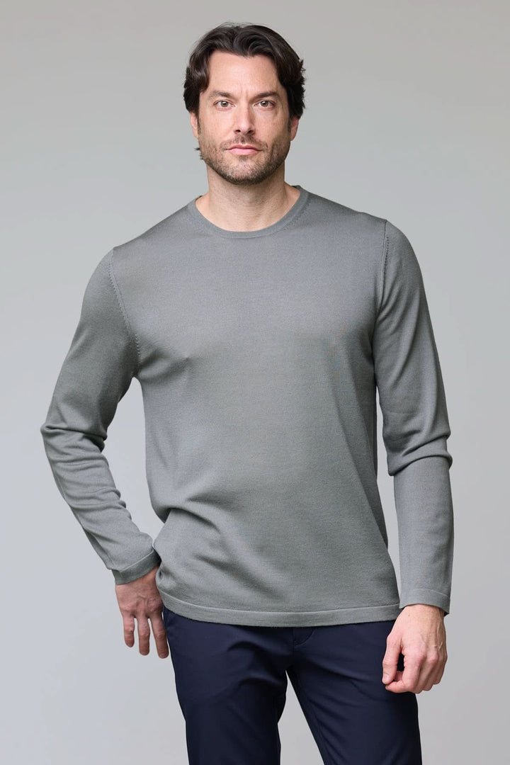 Homme portant un chandail col rond en tricot fin gris, texture douce et élégante, coupe ajustée, adapté pour un style raffiné.