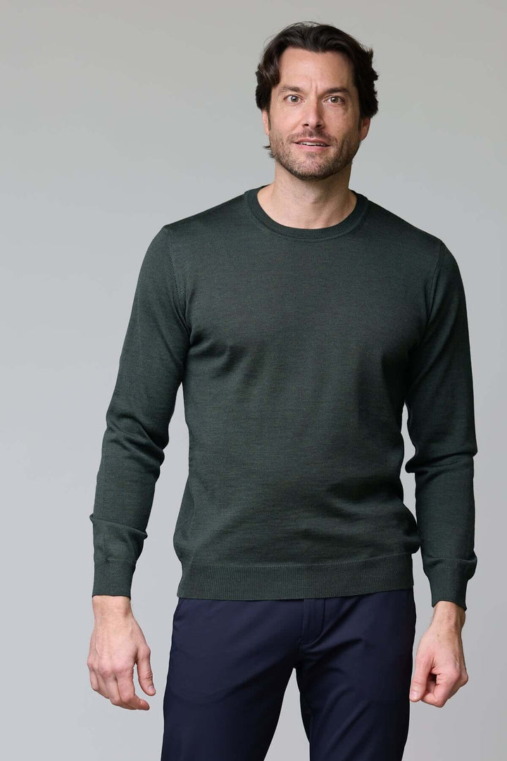 Homme portant un chandail col rond en laine mérinos, parfait pour une allure élégante et confortable.