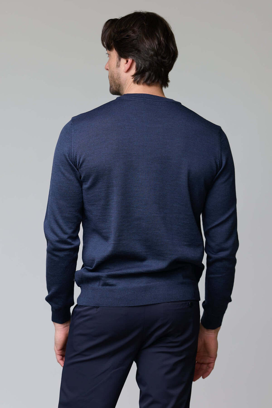Homme portant un chandail col roulé en laine mérinos vu de dos, montrant le design ajusté et la texture douce du tissu.
