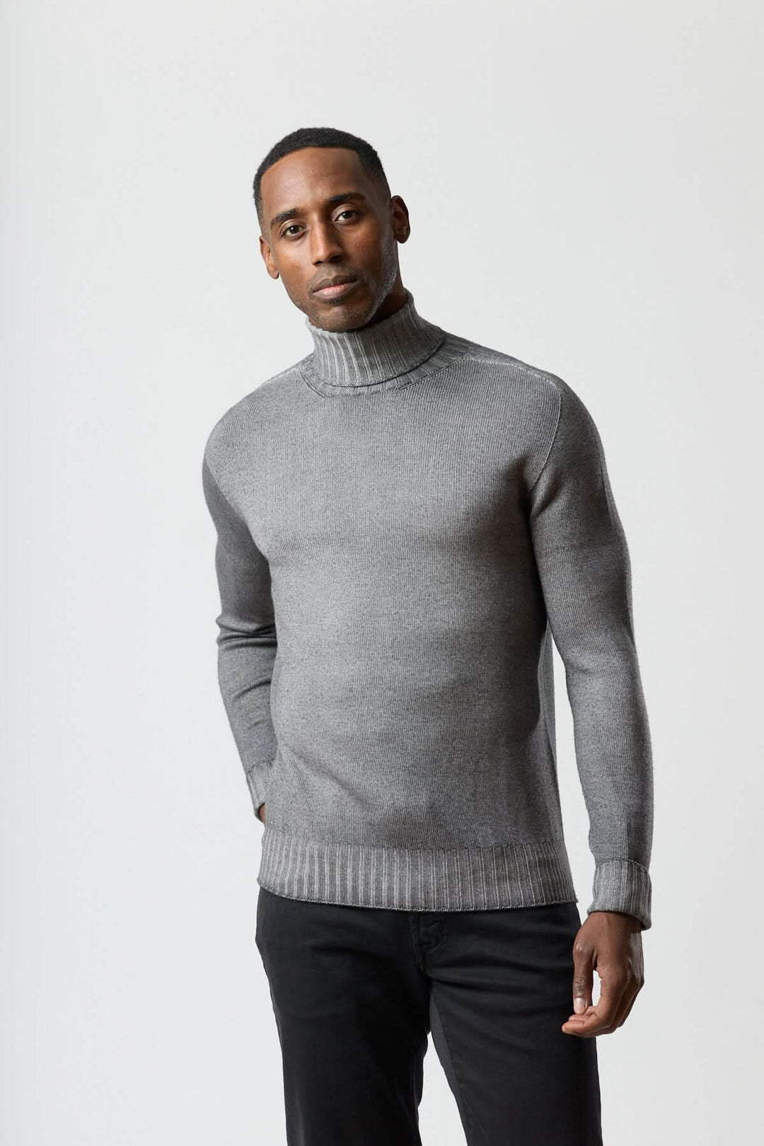 Homme portant un chandail col roulé jauge fine gris en maille douce pour un style moderne et net.