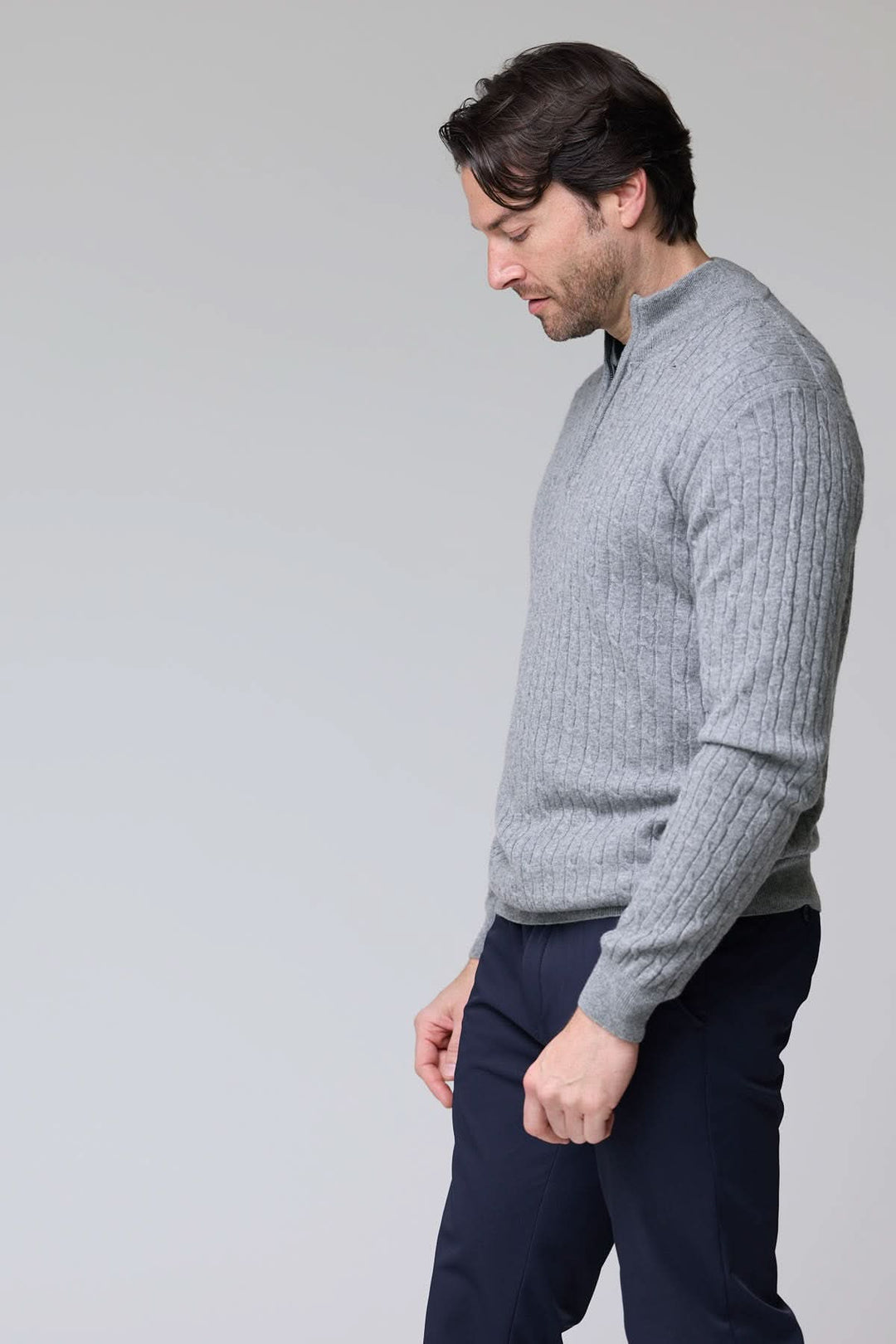 Homme portant un chandail à demi-glissière torsadé en laine gris, élégant et confortable.