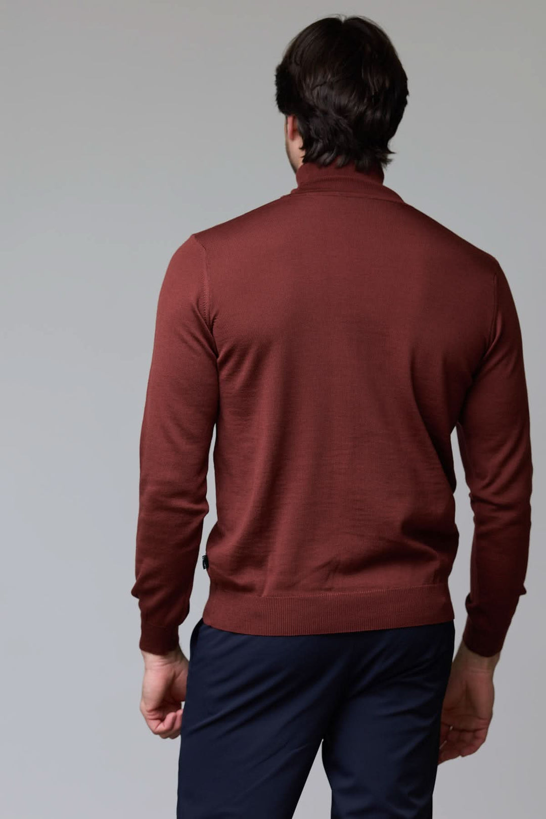 Homme portant un chandail en laine mérinos fine marron avec coupe droite et col rond, idéal pour style élégant et intemporel.