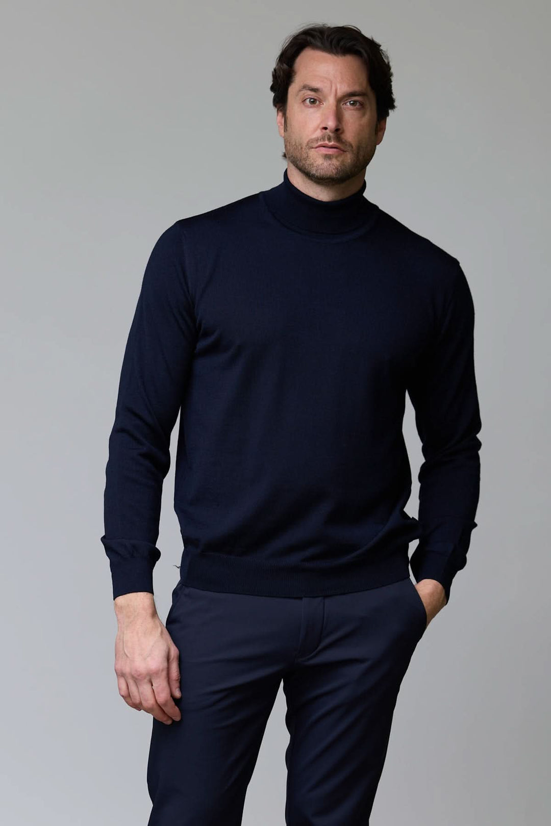 Homme portant un chandail en laine mérinos fine avec col rond, style élégant et intemporel, tricot léger et respirant.
