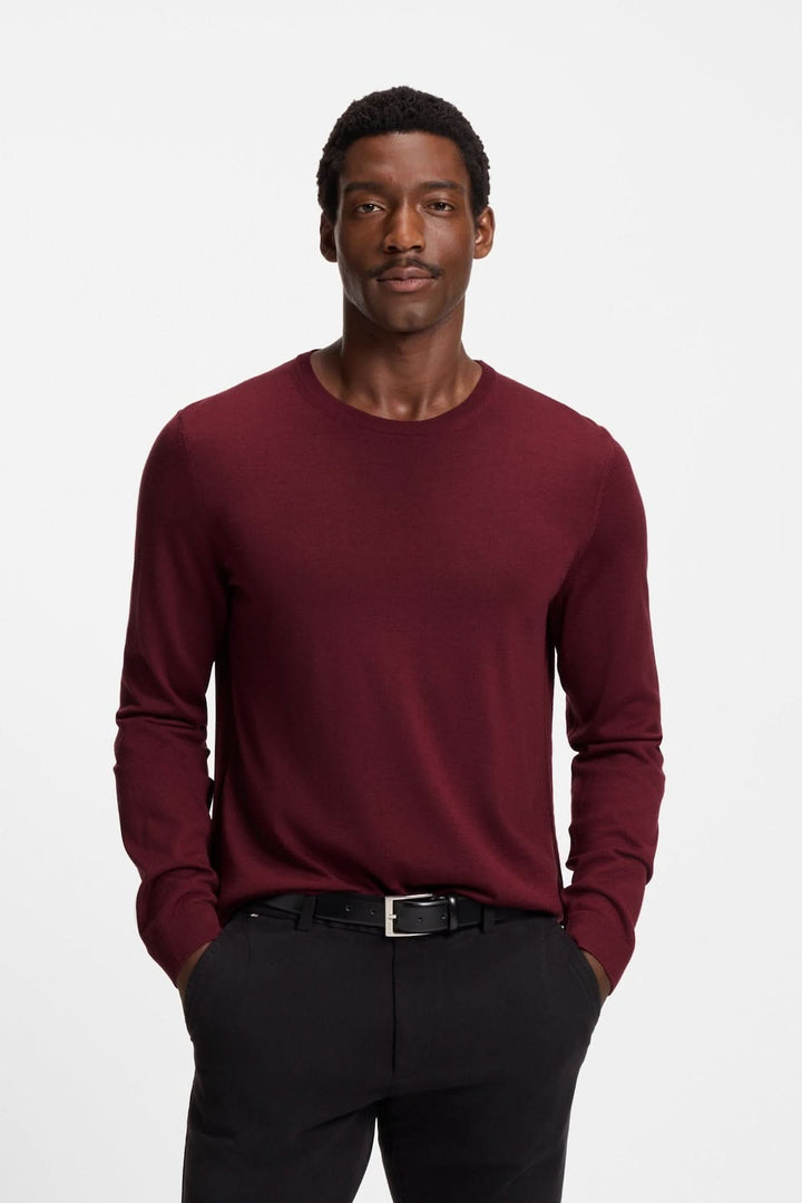 Homme portant un Chandail en laine vierge Leno de couleur bordeaux, coupe ajustée avec encolure ronde, élégance et confort.