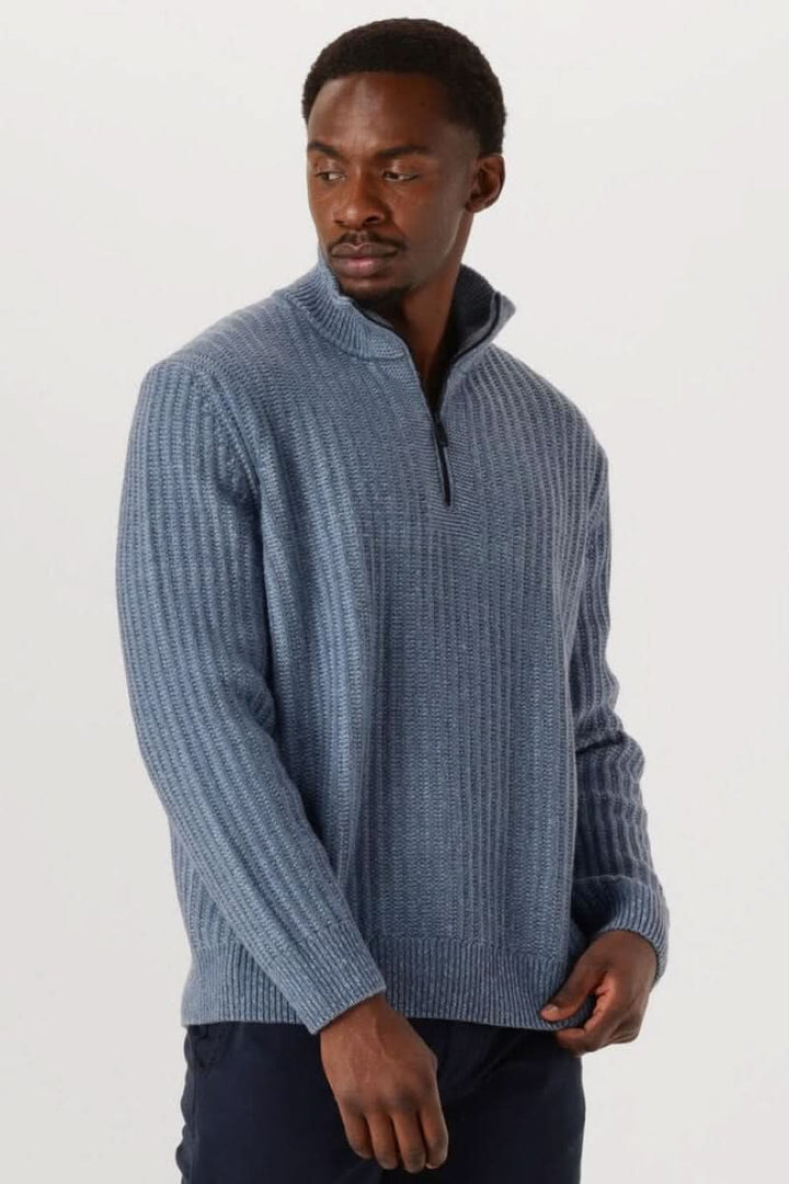 Chandail en tricot à demi-glissière côtelé bleu porté par un homme. Col zippé moderne et structuré pour un style décontracté et soigné.
