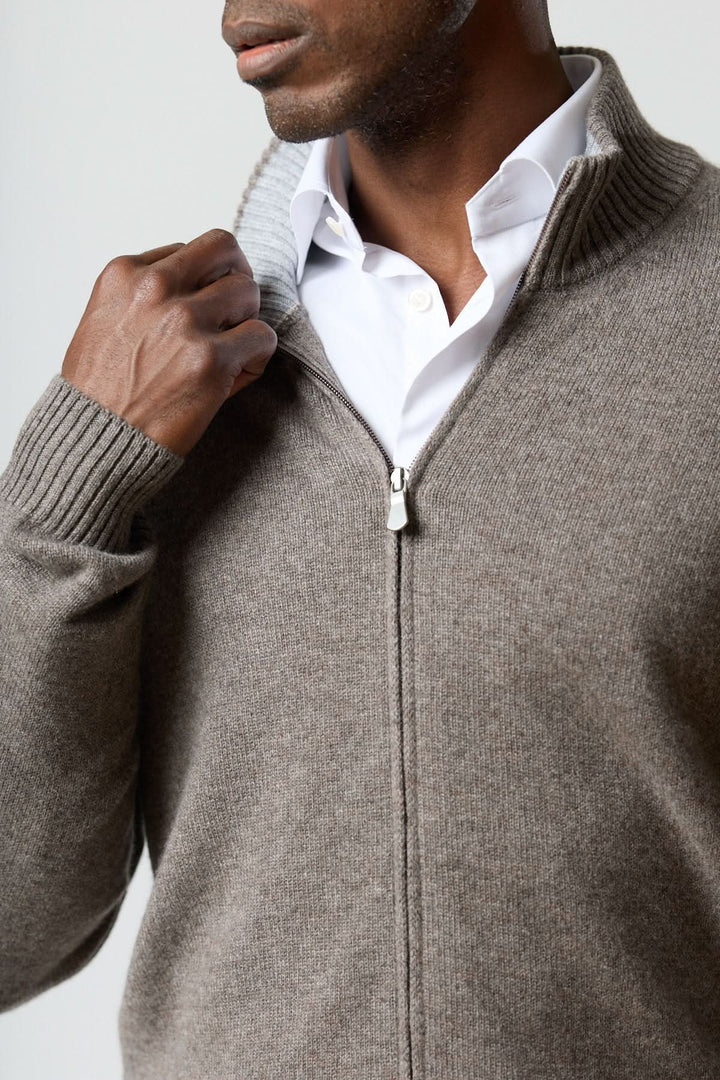 Chandail zippé col montant en maille douce avec fermeture à glissière, porté sur chemise blanche pour un look masculin élégant.