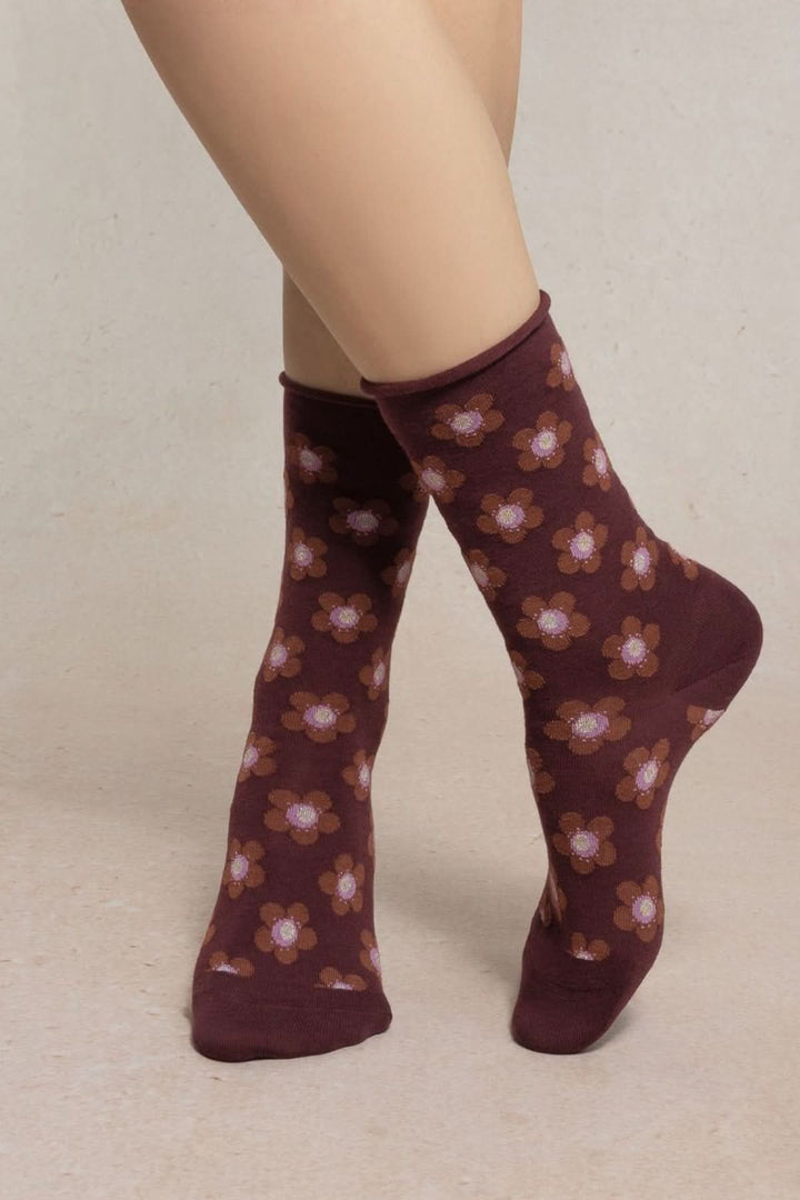 Chaussettes en maille à petit motif floral portées avec un motif floral coloré, longueur mi-mollet, bord-côte souple.