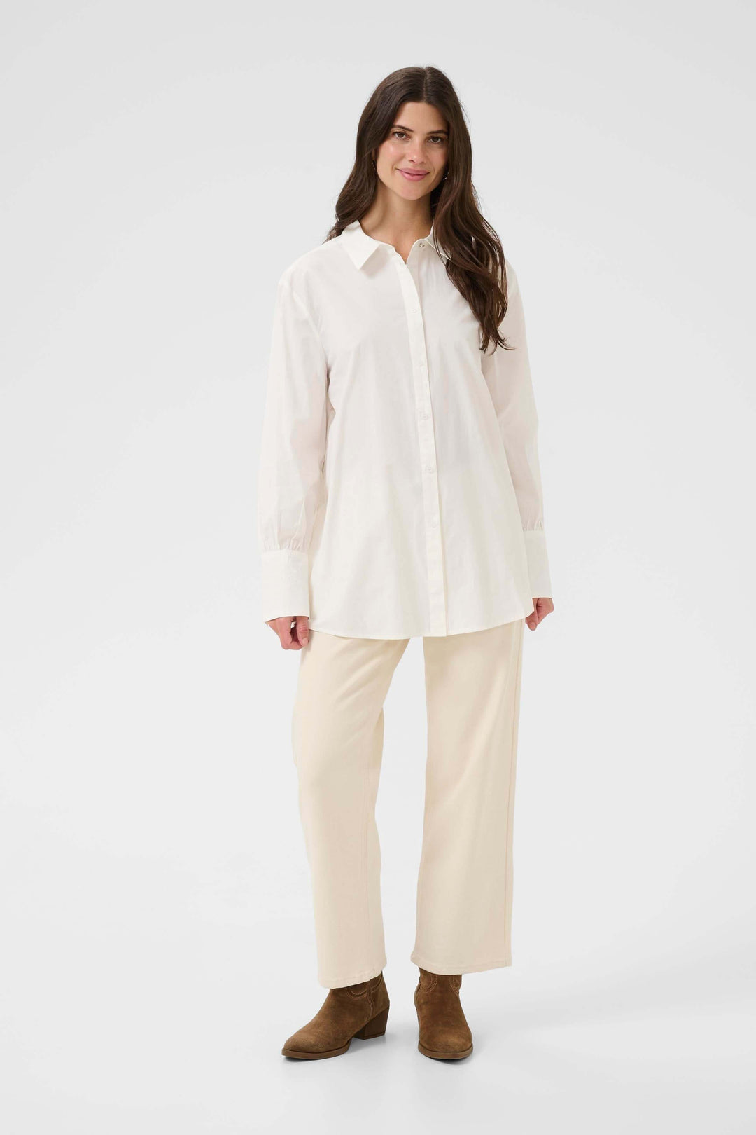 Femme portant la Chemise Alison élégante et fluide en blanc, avec col classique et coupe décontractée.