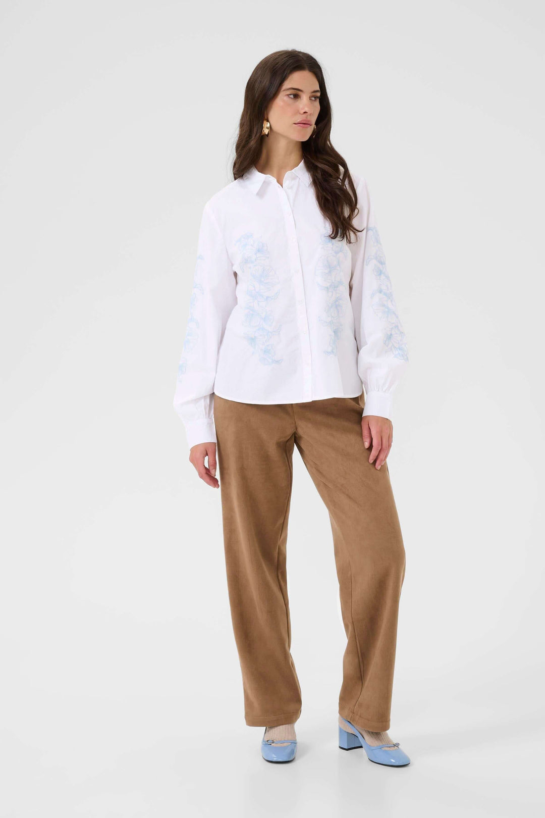 Femme portant la Chemise Jolene avec motif floral, coupe fluide et col classique, style élégant pour contexte professionnel ou décontracté.