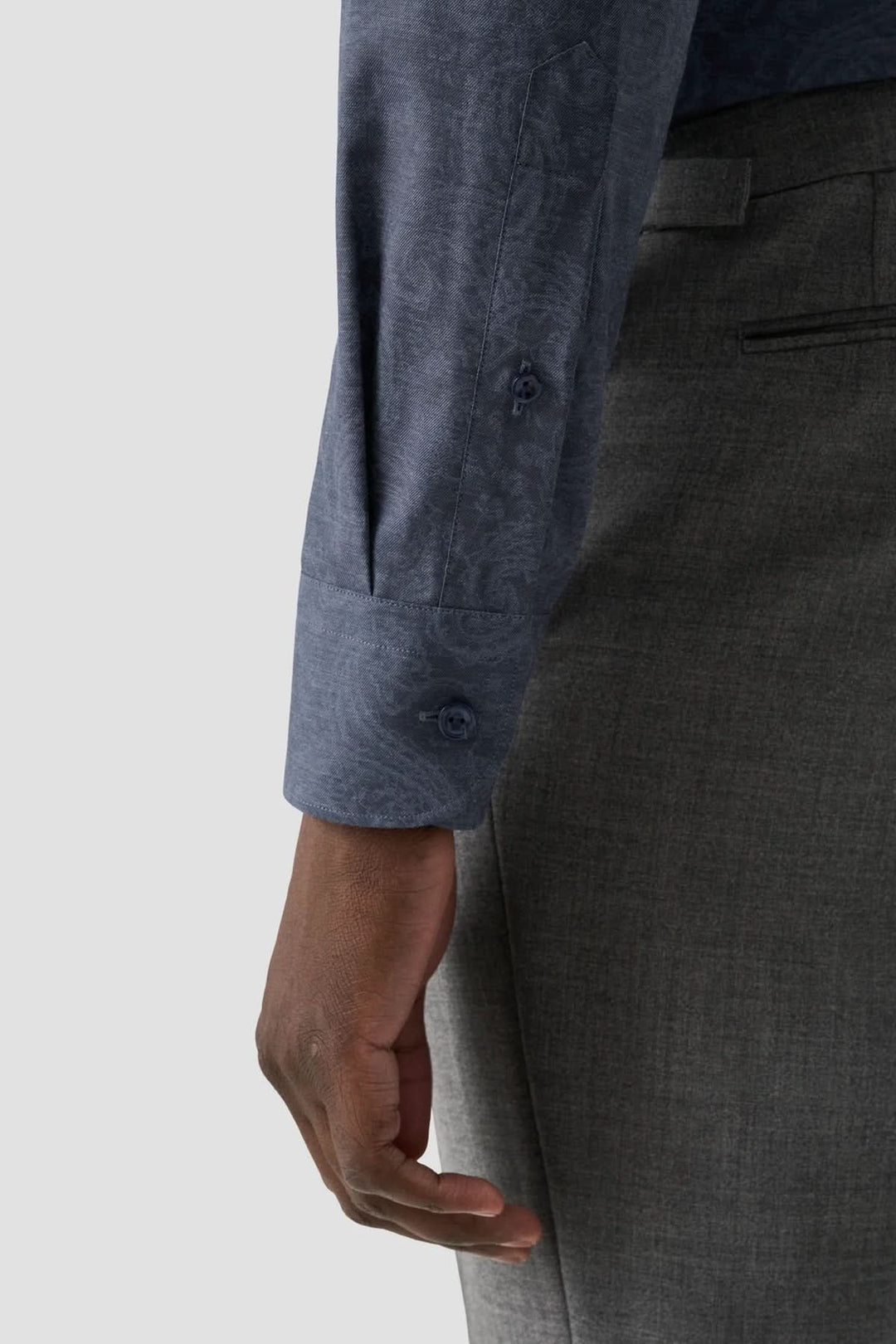 Chemise ajustée à imprimé cachemire, manches longues avec motif paisley, portée avec un pantalon gris élégant.
