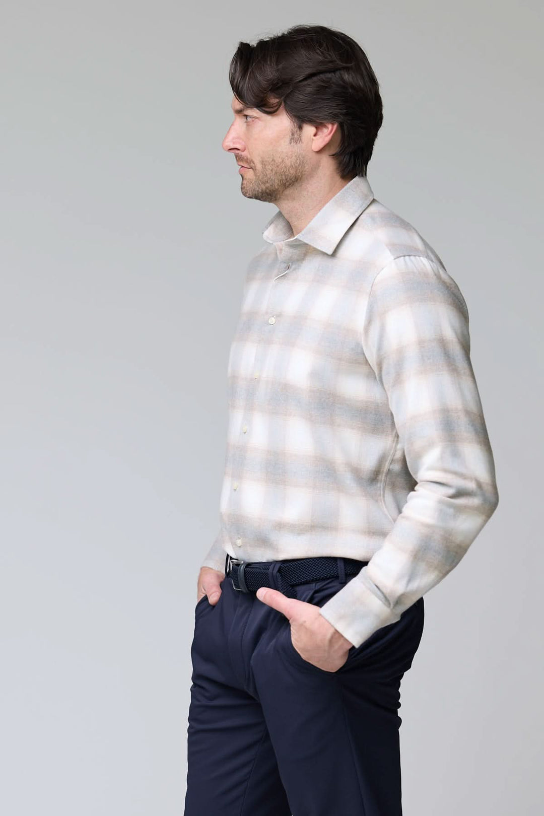 Homme portant une chemise à carreaux doux en flanelle avec col semi-rigide et boutons nacrés, style moderne et confortable.