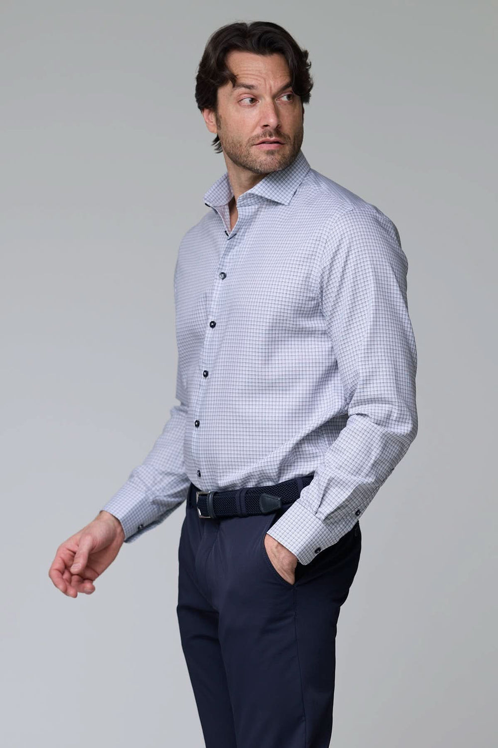 Homme portant une chemise à carreaux fins, manches longues, coupe ajustée, motif à petits carreaux, pour un look professionnel décontracté.