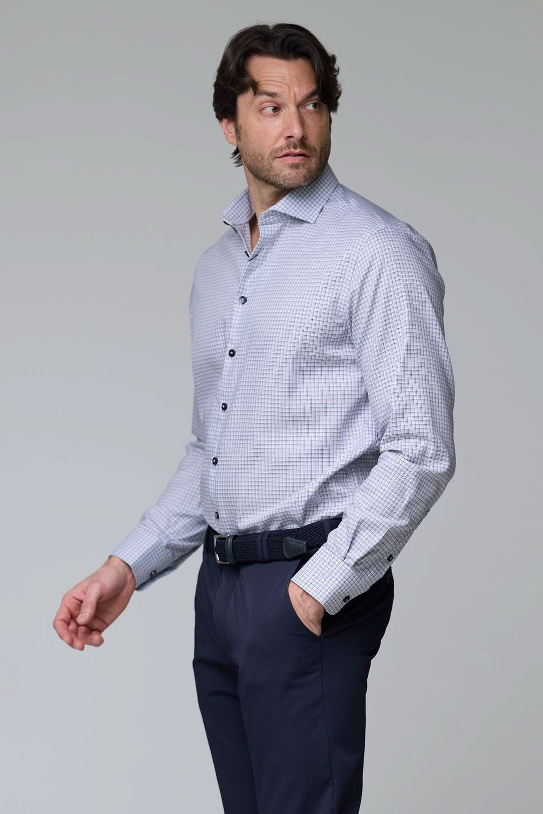 Homme portant une chemise à carreaux fins, manches longues, coupe ajustée, motif à petits carreaux, pour un look professionnel décontracté.