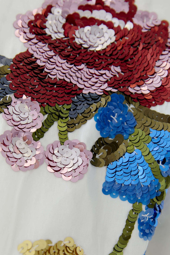 Broderies florales sur chemise coupe moderne, élégance féminine.
