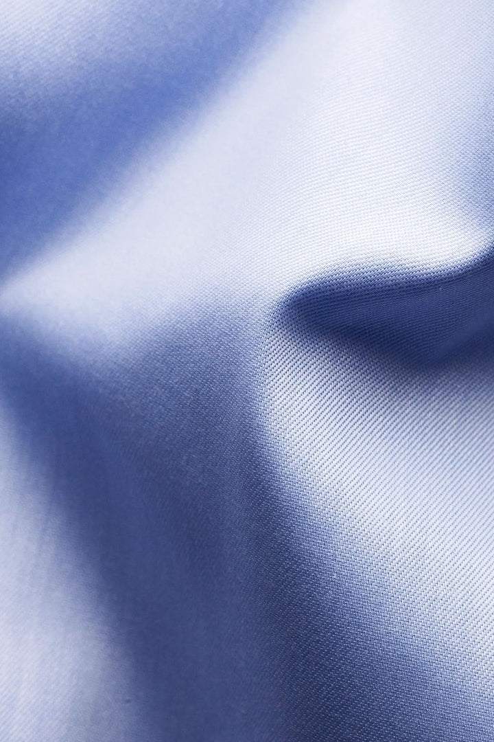 Texture du tissu en coton bleu de la chemise en coton signature à col italien pour un style élégant et raffiné.