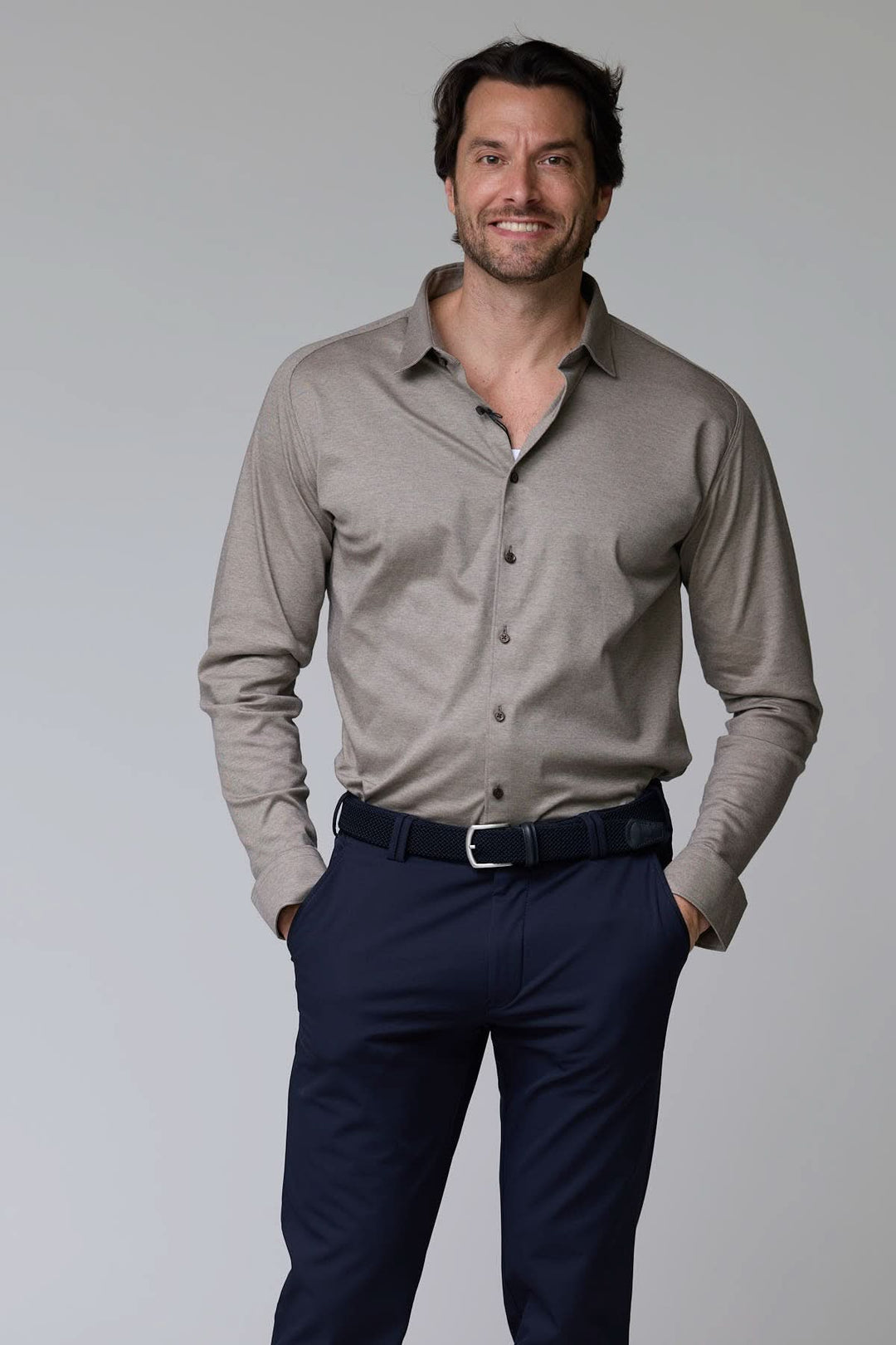 Homme portant une chemise en jersey extensible à manches longues, coupe ajustée avec col structuré, style décontracté chic.