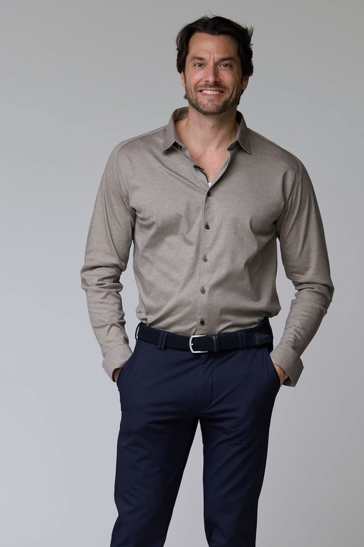 Homme portant une chemise en jersey extensible à manches longues, coupe ajustée avec col structuré, style décontracté chic.
