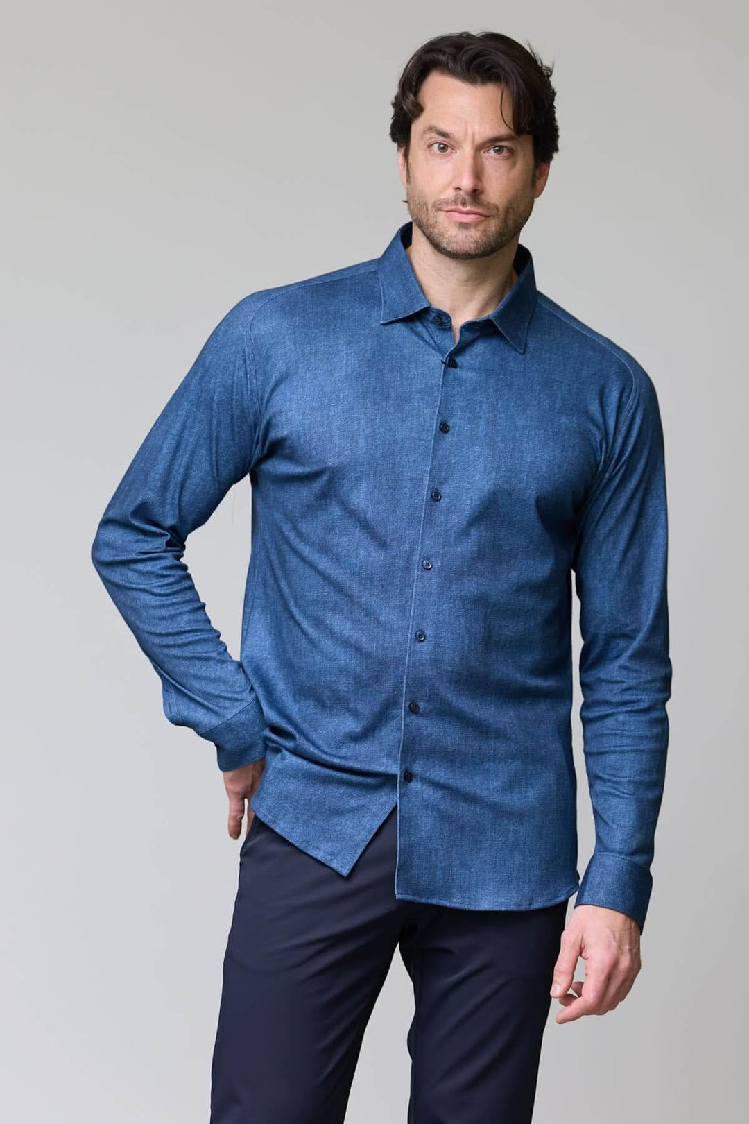 Homme portant une chemise en jersey extensible bleue avec manches longues et col rigide pour un look élégant et décontracté.