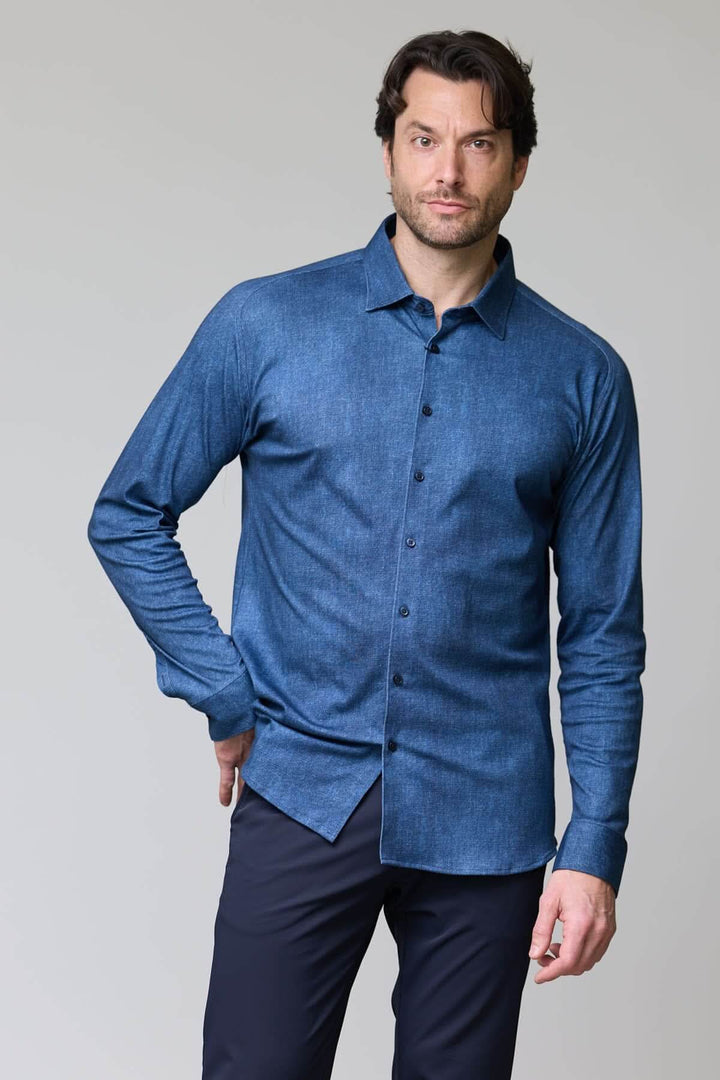 Homme portant une chemise en jersey extensible bleue avec manches longues et col rigide pour un look élégant et décontracté.