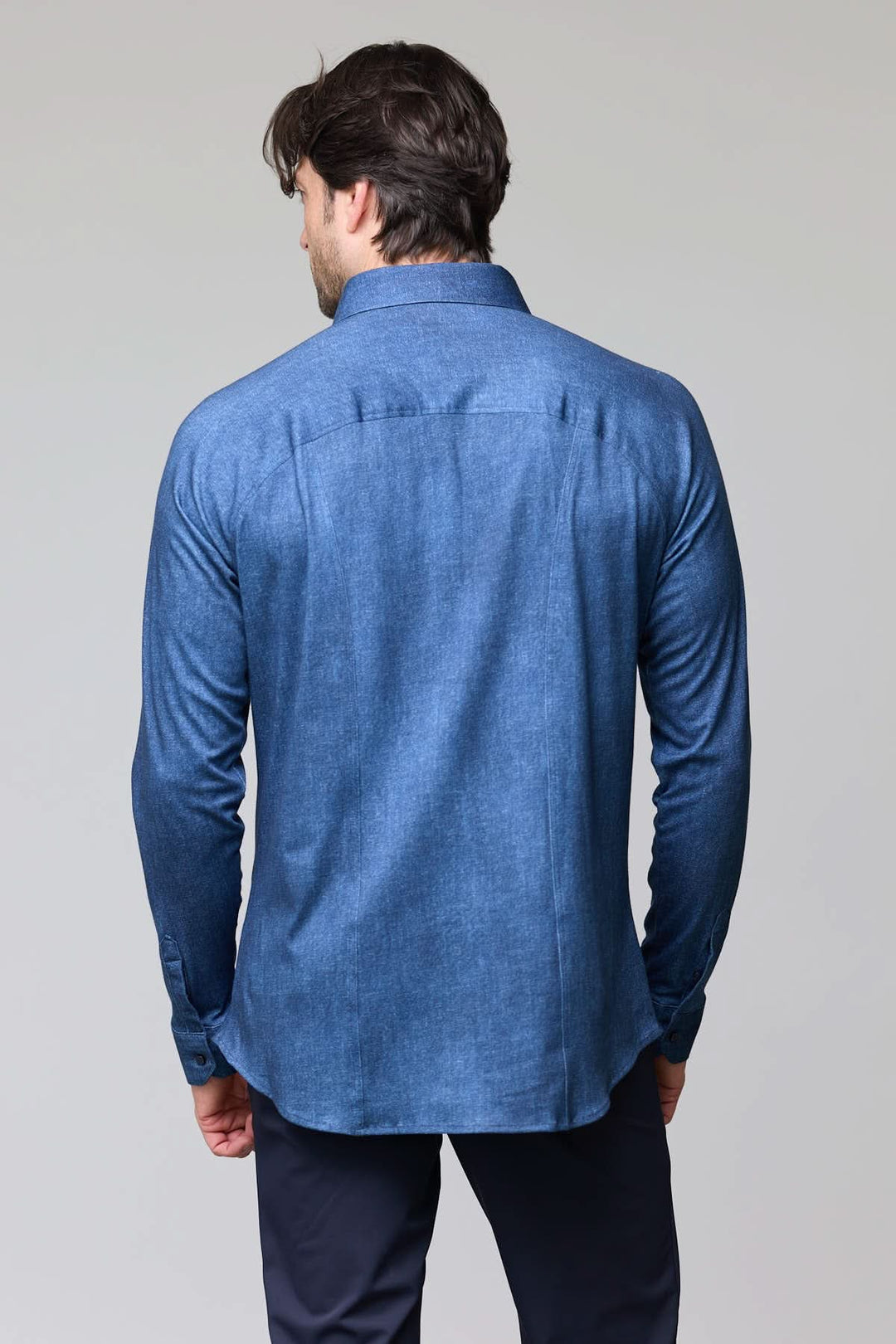 Homme portant une Chemise en jersey extensible bleue de dos, manches longues, coupe moderne.