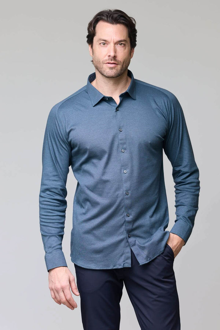 Homme portant une chemise en jersey extensible bleu avec manches longues et col rigide, coupe ajustée.