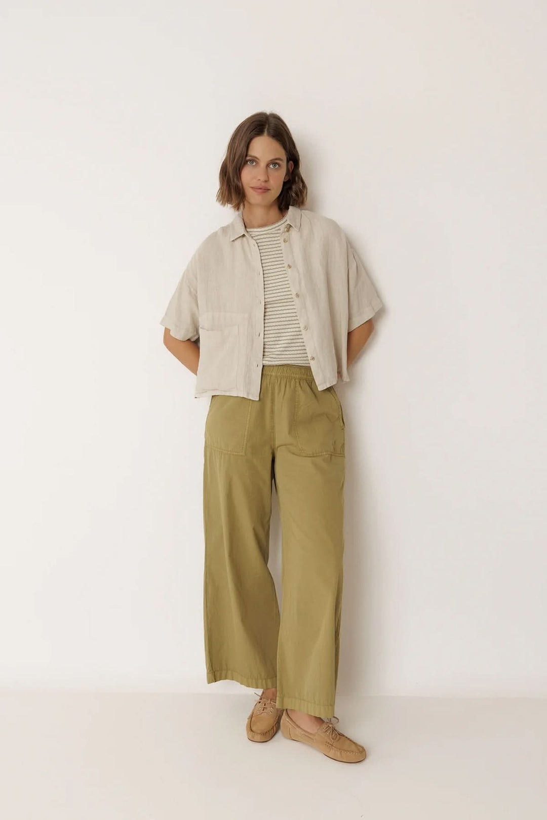 Femme portant une chemise en lin à coupe décontractée avec un pantalon kaki, style estival élégant.