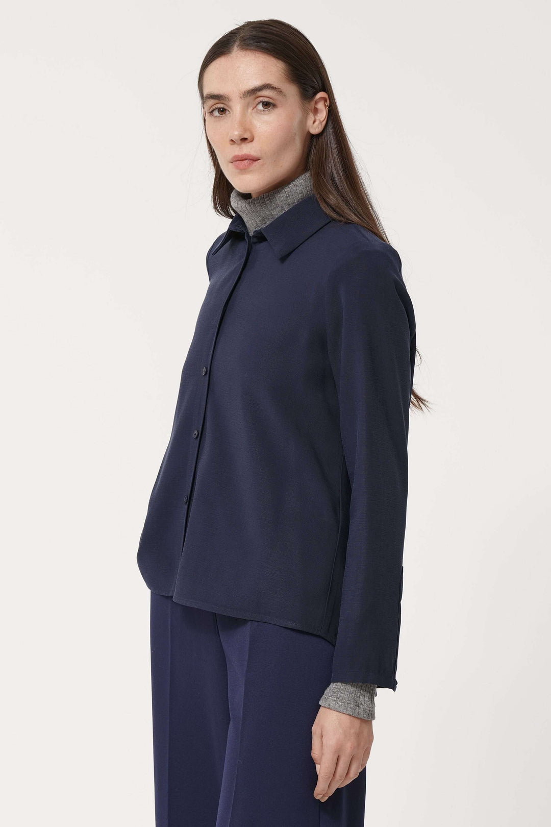Femme portant une chemise fluide élégante avec col classique et coupe ample, idéale pour un look de bureau chic et minimaliste.