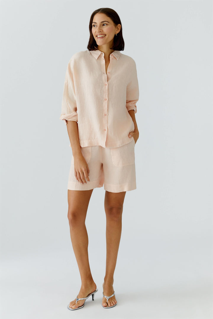 Femme portant une chemise fluide à manches longues dans un tissu léger et élégant pour un look raffiné et décontracté.