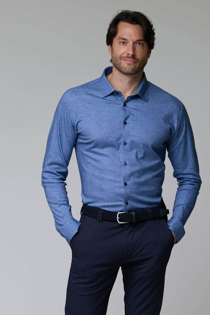 Homme portant une chemise jersey texturé bleue à manches longues avec un col structuré.