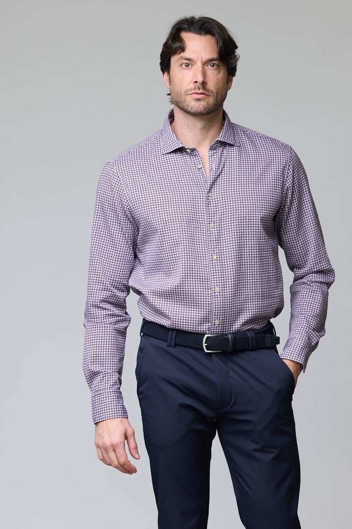 Homme portant une chemise à motif géométrique avec manches longues et coupe ajustée, parfaite pour un style professionnel et moderne.
