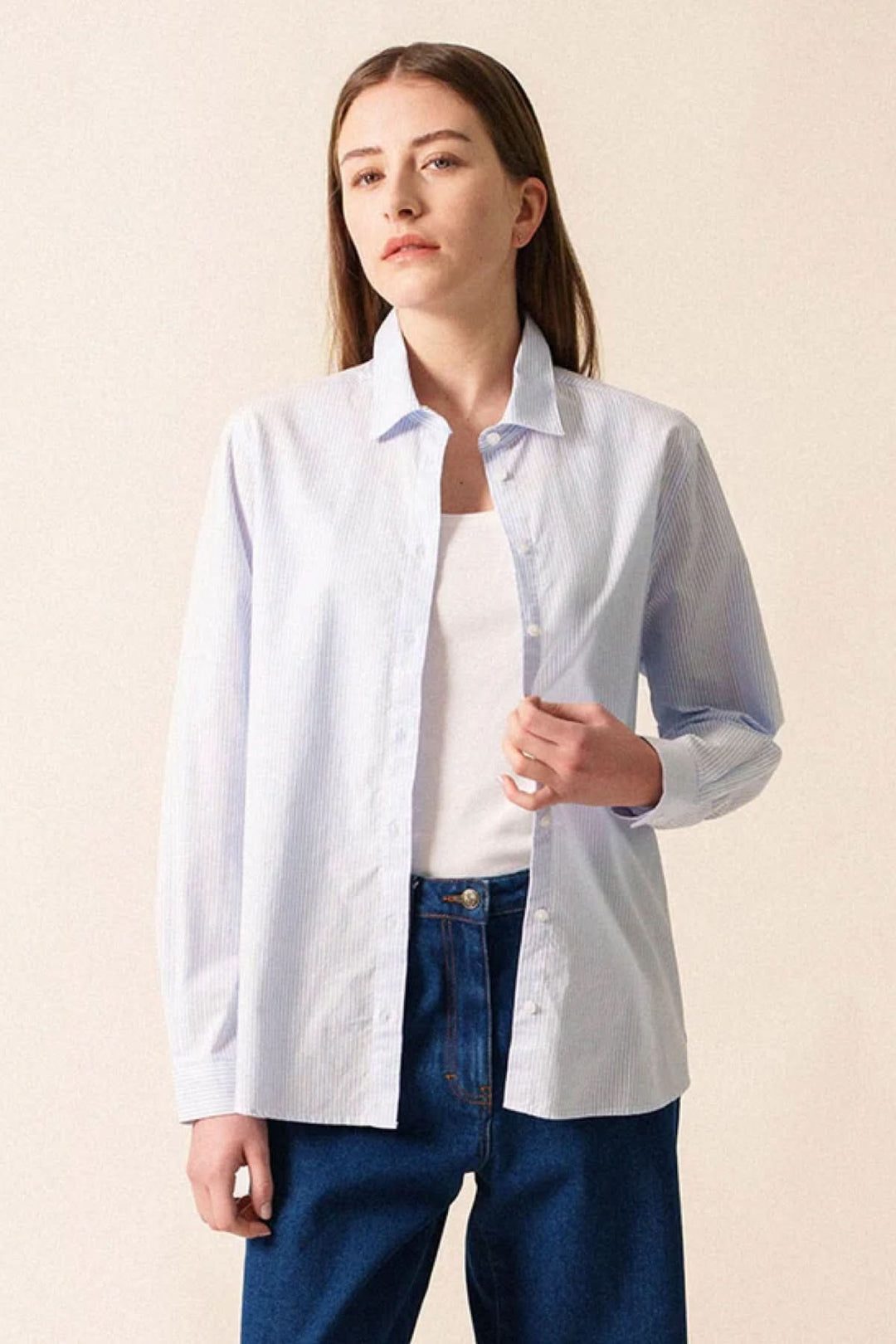 Femme portant une chemise rayée LENA en coton avec coupe droite pour un style élégant et décontracté.