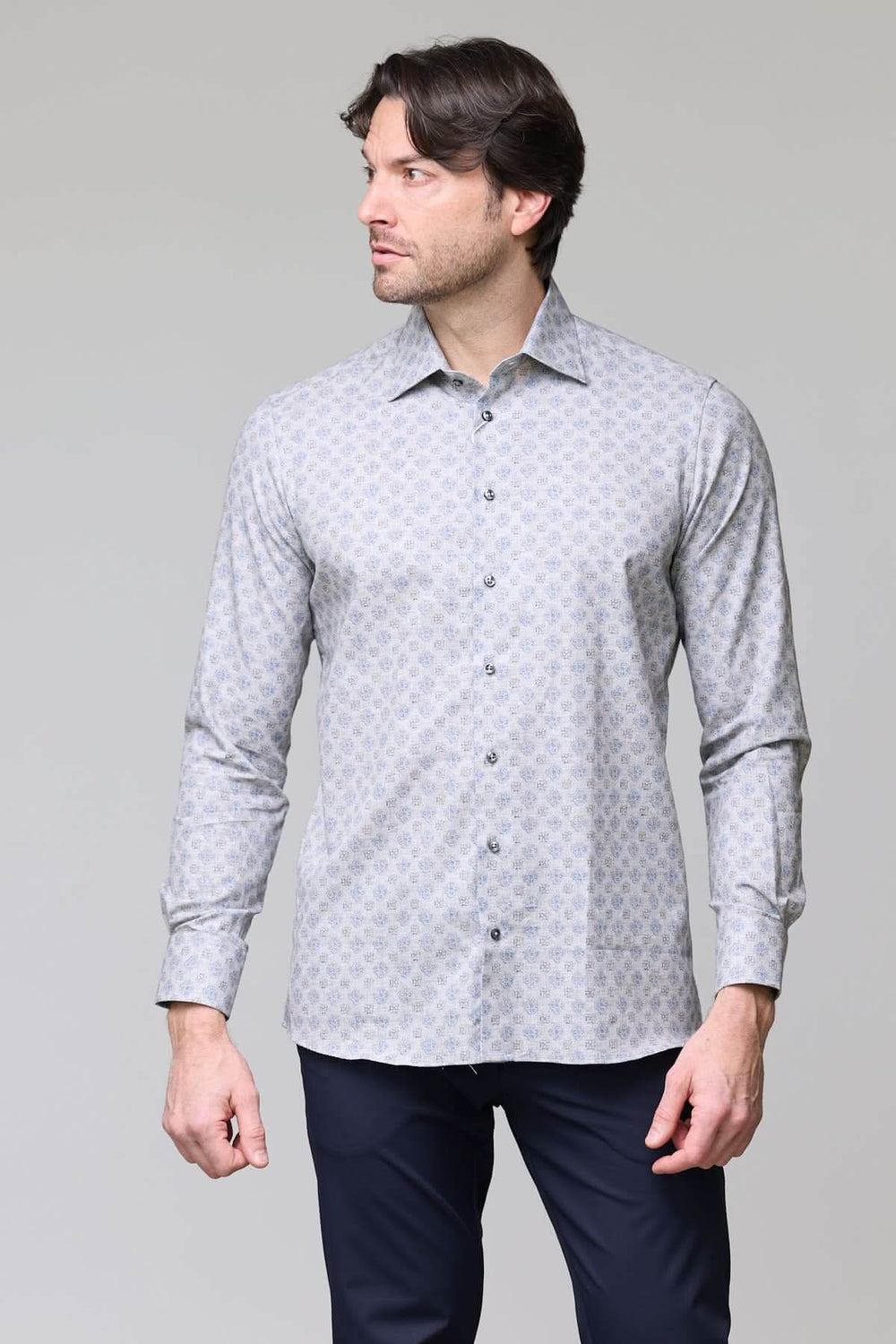 Homme portant une chemise sport à motif géométrique bleu pâle, coupe ajustée moderne, col classique et boutons contrastants bleus nacrés.