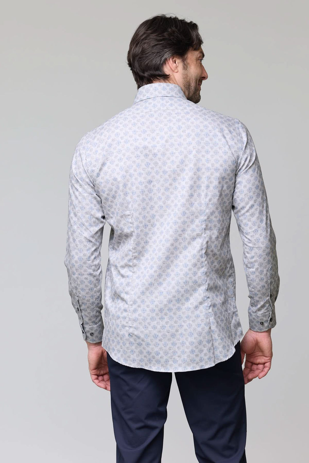 Homme portant une chemise sport à motif géométrique bleu pâle, vue de dos, soulignant la coupe ajustée et élégante.
