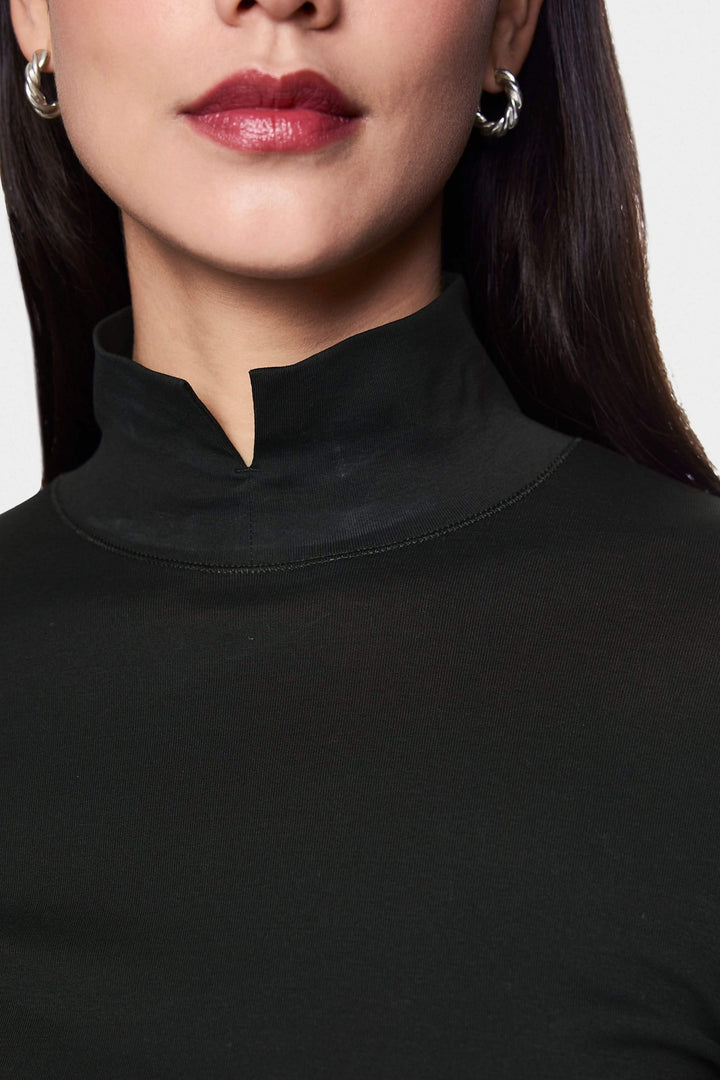 Femme portant un col roulé ajusté noir avec col fendu et détails raffinés pour un style moderne et élégant.