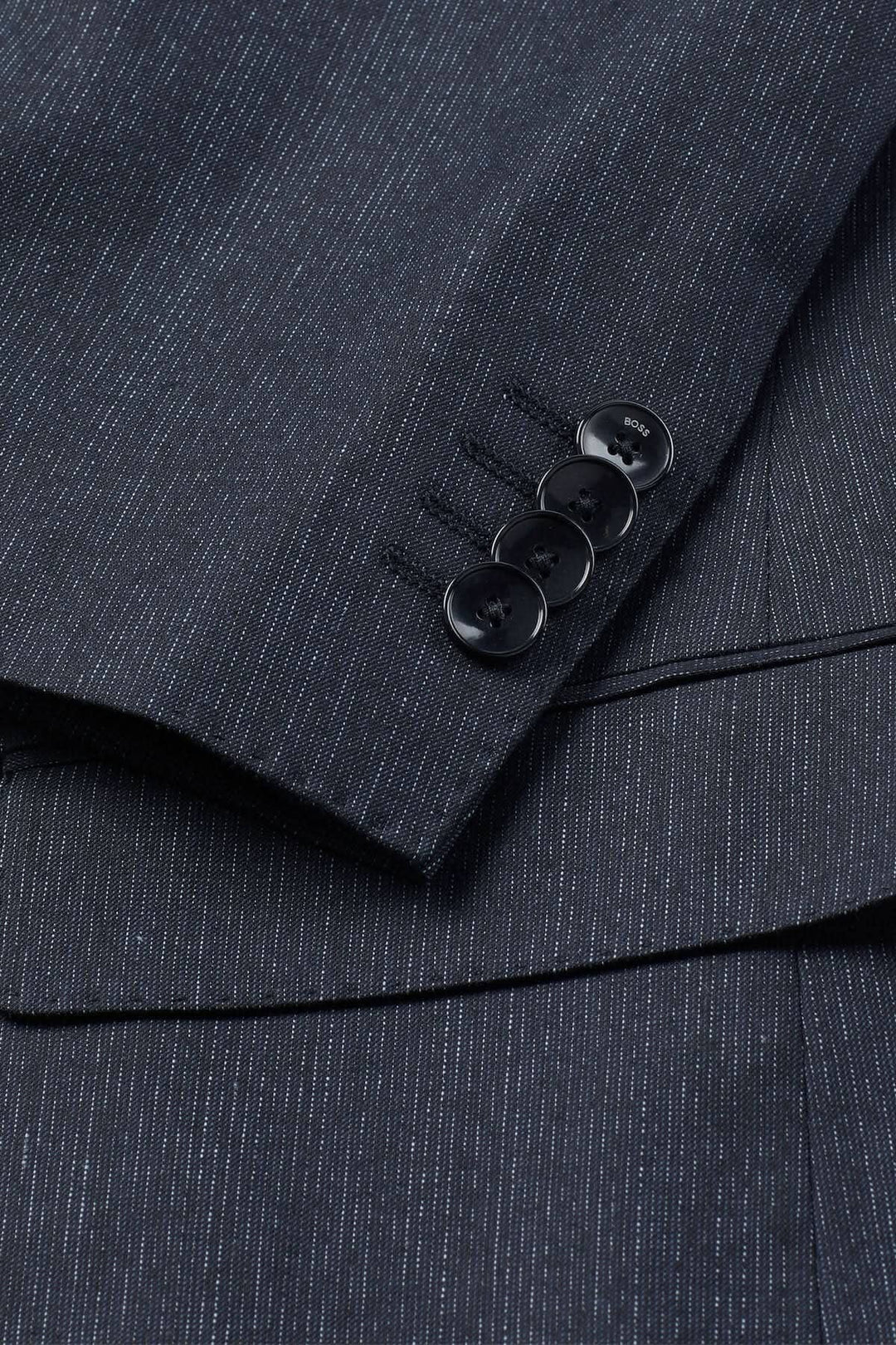 Complet à micro-motifs noir avec boutons élégants sur la manche, parfait pour une tenue professionnelle.
