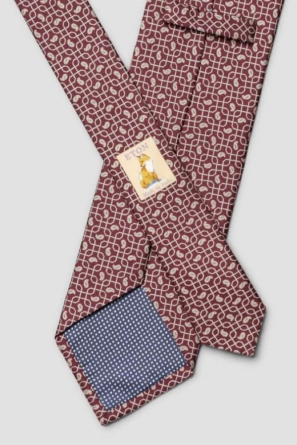 Cravate à motif géométrique en soie italienne, finition lustrée, doublure contrastante, parfaite pour événements élégants.